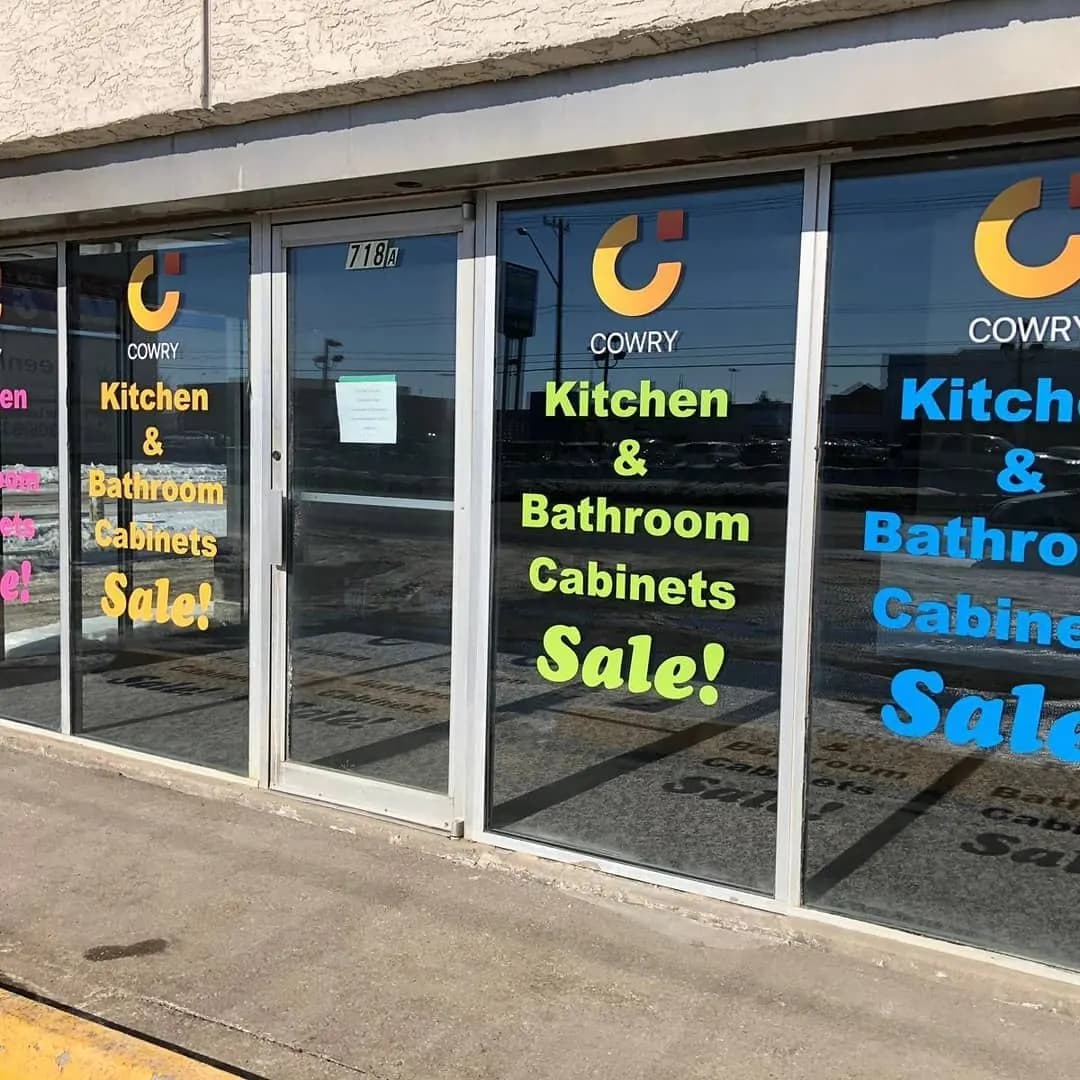 Cowry Cabinets storefront sale window lettering installed in Saskatoon