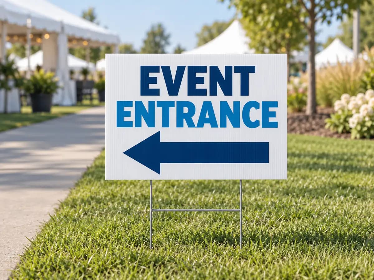 Illustrative event entrance sign with a left arrow on a lawn stake